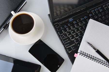 open notebook, mobile  phone,  pen and cup of coffeeの写真素材