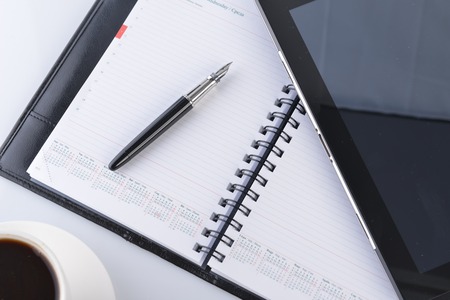 open notebook, mobile  phone,  pen and cup of coffeeの写真素材