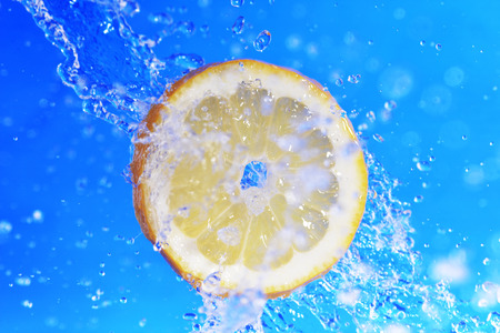 slice of lemon in the water with bubbles on blue backgroundの写真素材
