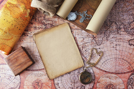 Vintage compass and a pocket watch lying on  old mapの写真素材