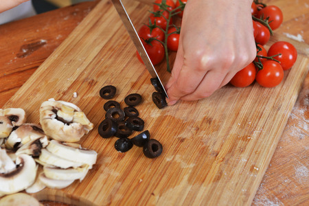 mother with daughter cut vegetables for pizzasの写真素材