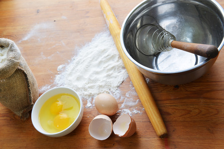 Kitchen rolling pin, eggs  and flour on wooden backgroundの写真素材