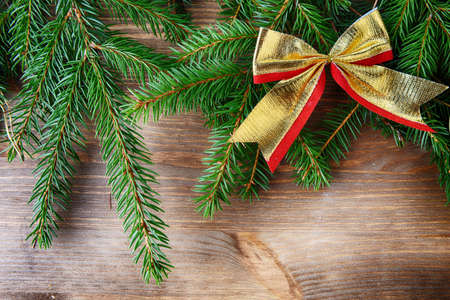 branch of green fir tree with christmas toys on wooden backgroundの写真素材