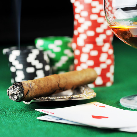 Cigar, chips for gamblings, drink and playing cards on greenの写真素材