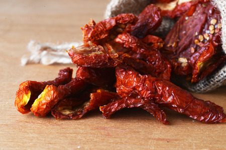 Dried tomatoes got enough sleep from canvas bag at wooden backgroundの写真素材