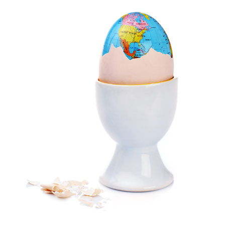 Earth inside cracked egg isolated on whiteの写真素材