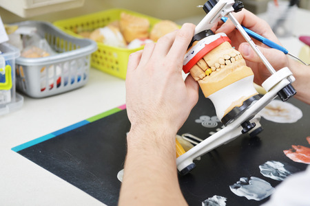 dental technician working on false teeth. table with dental tools.の写真素材