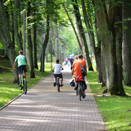 Cyclists ride along  bike path in parkの写真素材