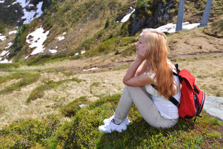 young woman sitting on  mountain slopeの写真素材