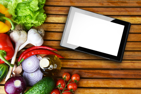 fresh vegetables and tablet on wooden tableの写真素材