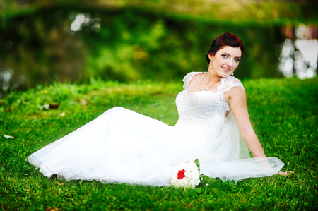 beautiful bride sitting on grassの写真素材