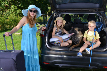 children and dog sits in carの写真素材