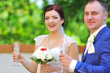 groom and bride in white dress on background of green treesの写真素材