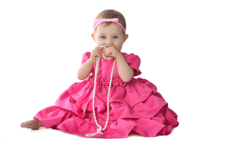 Adorable little baby girl  in  pink dress sitting on floorの写真素材