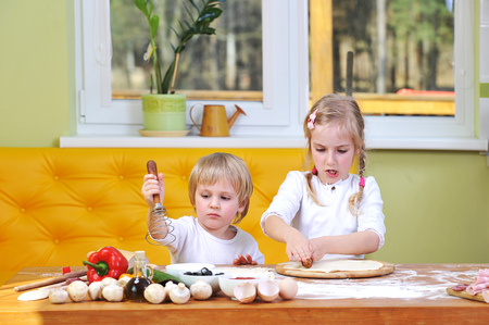 children helps mother to prepare pizzaの写真素材