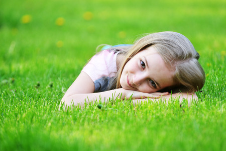 girl lies on green grassの写真素材