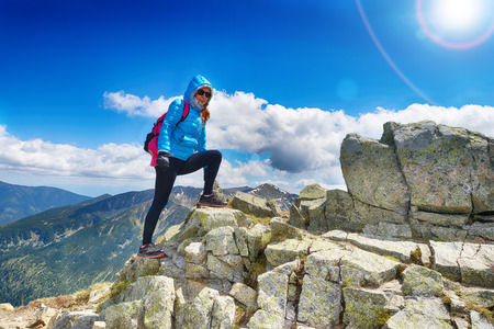 young woman in mountains, background of sky and cloudsの写真素材