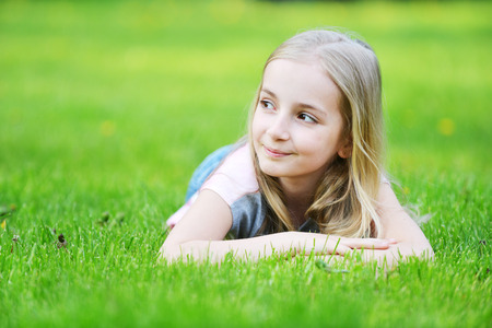 girl lies on green grassの写真素材