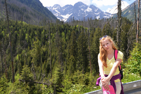 young woman on mountains slopes near roadの写真素材
