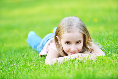 girl lies on green grassの写真素材