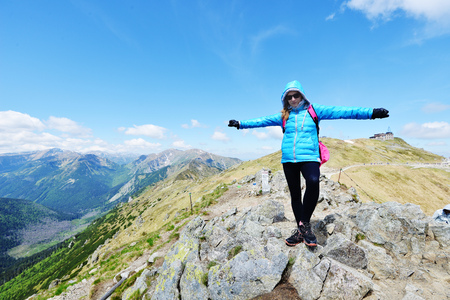 young woman in mountains, background of sky and cloudsの写真素材