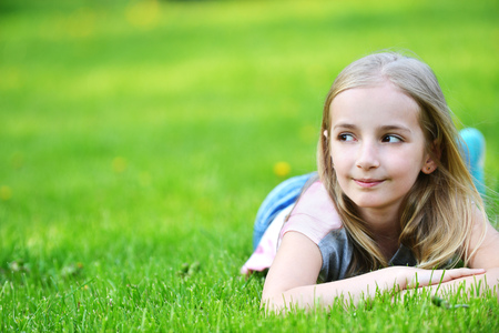 girl lies on green grassの写真素材