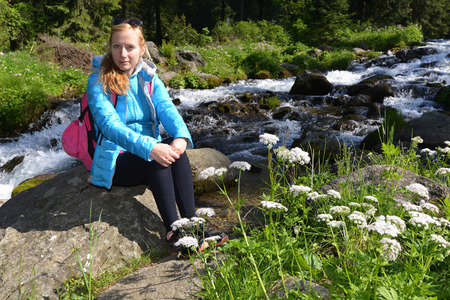 young woman on mountains slopes near creekの写真素材