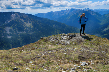 young woman in mountains, background of sky and cloudsの写真素材