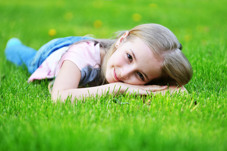 girl lies on green grassの写真素材