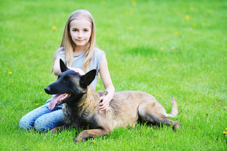girl playing with dogs on grassの写真素材