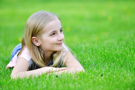 girl lies on green grassの写真素材