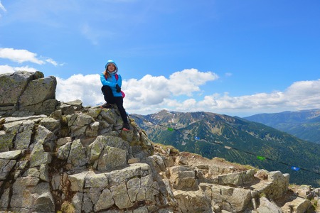 young woman in mountains, background of sky and cloudsの写真素材