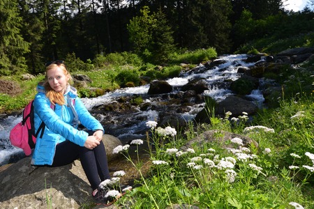young woman on mountains slopes near creekの写真素材