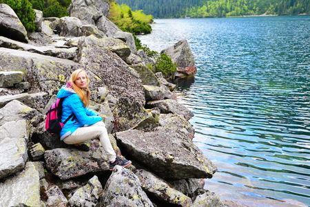 young woman on mountains slopes near waterの写真素材