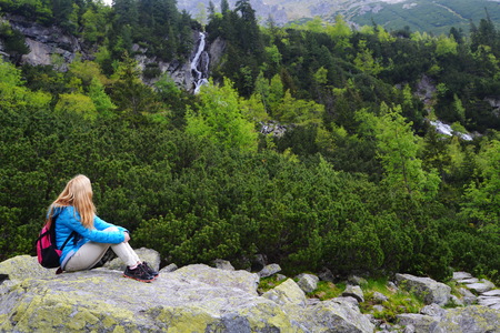 young woman in blue jacket on mountains slopesの写真素材