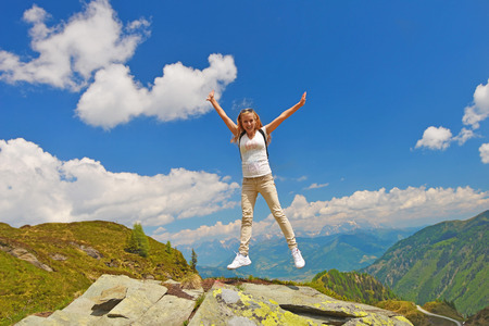 young woman on top of mountain,  background  of sky and cloudsの写真素材