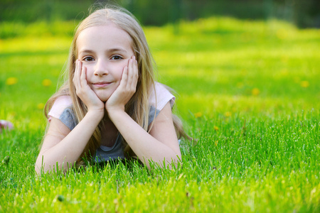 girl lies on green grassの写真素材