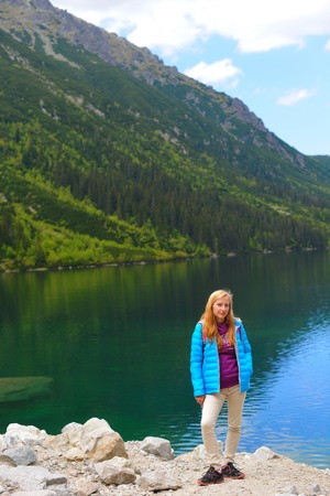 young woman on mountains slopes near waterの写真素材