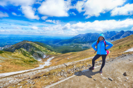 young woman in mountains, background of sky and cloudsの写真素材