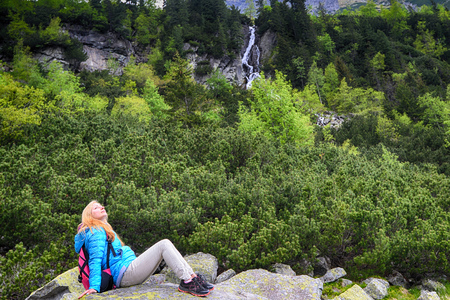 young woman in blue jacket on mountains slopesの写真素材
