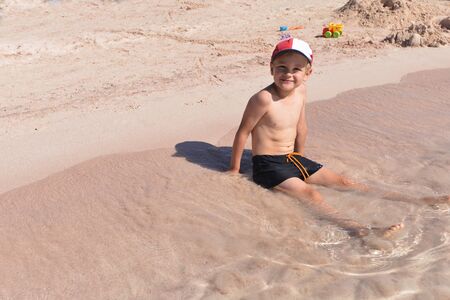 cute boy on shore of blue seaの写真素材