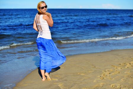Young woman walking on sand beachの写真素材