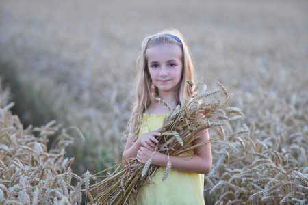 beautiful girl holding sheaf  of wheatの写真素材