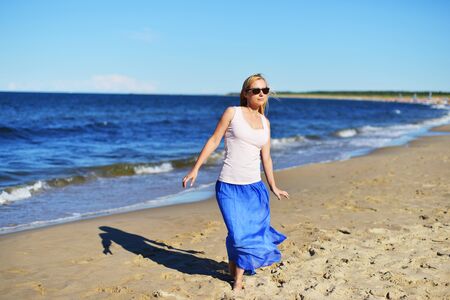 Young woman walking on sand beachの写真素材