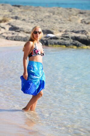 Young woman on shore of blue seaの写真素材