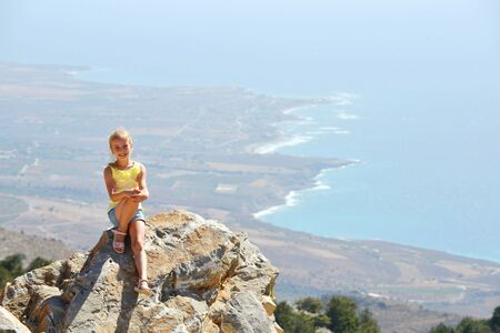 Beautiful girl on rock on background of  sea coastの写真素材