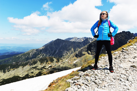 young woman in mountains, background of sky and cloudsの写真素材