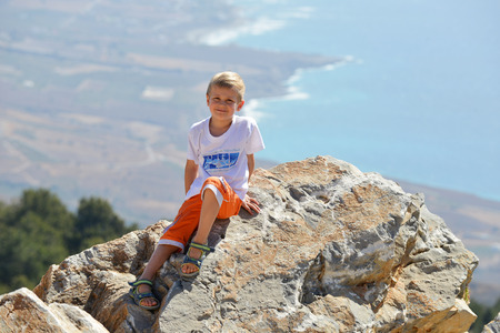 boy on top of mountain, background of skyの写真素材