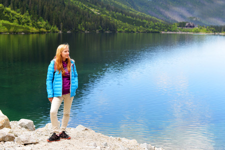 young woman on mountains slopes near waterの写真素材