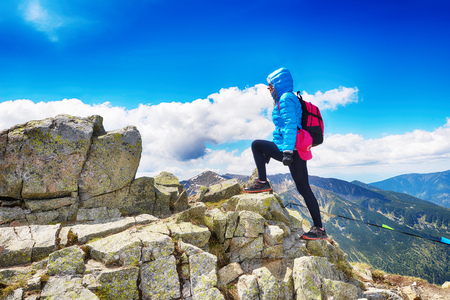 young woman in mountains, background of sky and cloudsの写真素材